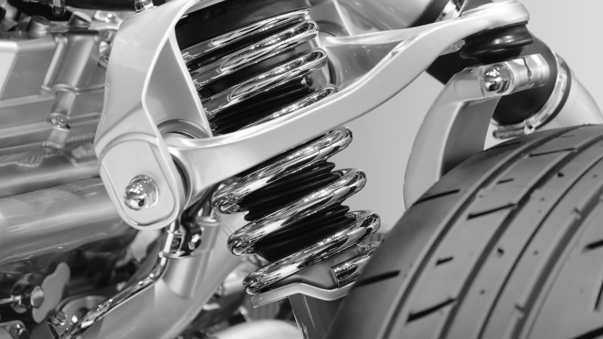 Close-up of car suspension spring and shock absorber in black and white