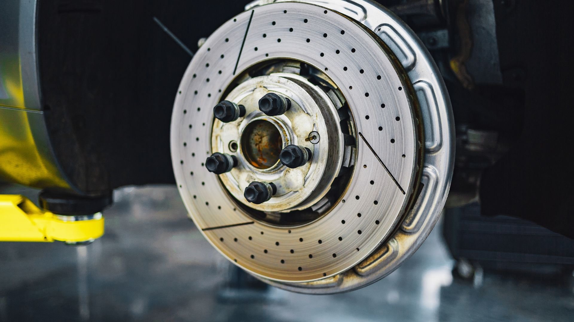 Close-up of a perforated automotive brake disc with wheel hub