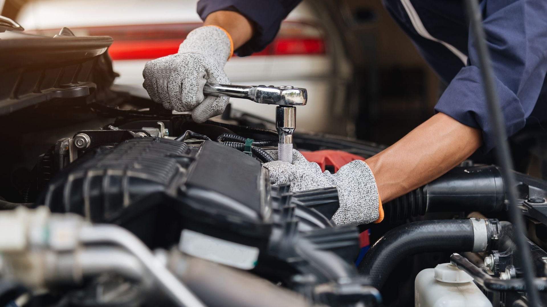 Mechanic using a ratchet wrench to repair a car engine